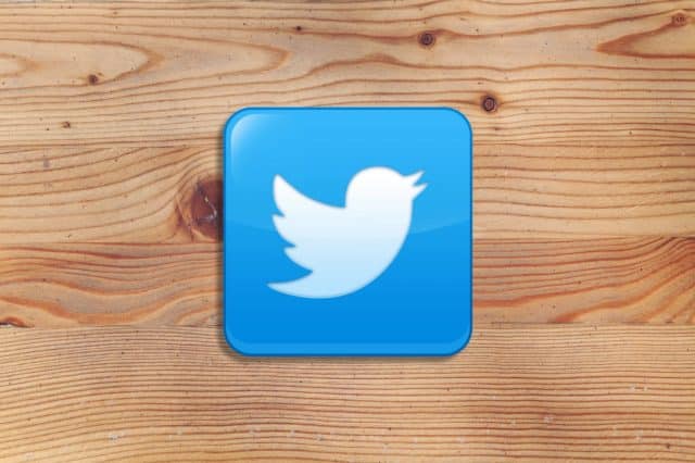 Twitter logo on wooden background