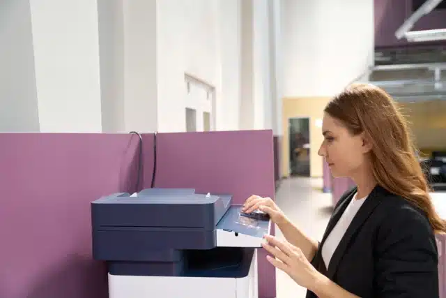 Woman using multi-function printer